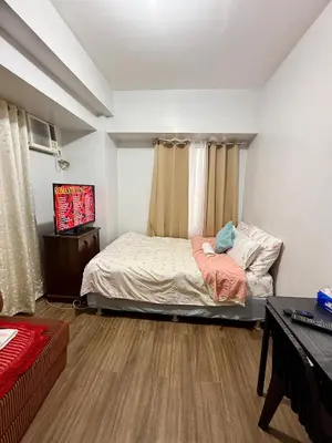 a bedroom with a bed and a television in it at 1BR LaVerti Cloud Nine Suite Family Affordable Staycation in Manila