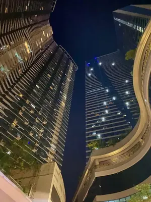 two tall buildings at night with the sky at Affordable Condo in Makati Air Residences in Manila