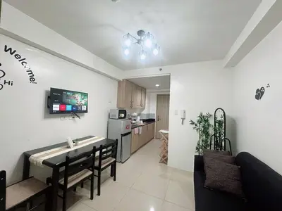 a kitchen and living room with a table and chairs at Shore Residences Moa View in Manila