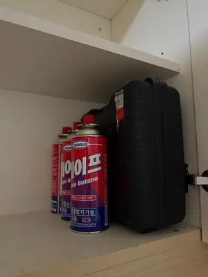 two cans and a suitcase sitting on a shelf at Casita avec Amour at Lumiere Residences in Manila