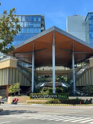 a building with a large wooden roof in a city at 1Bedroom, living room w balcony ADHI staycation in Biñan