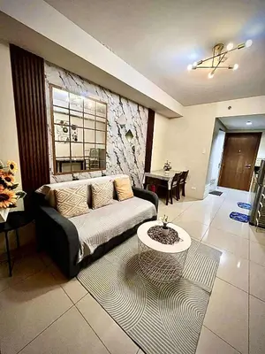 a living room with a couch and a table at Staycation Near Mall of Asia in Manila