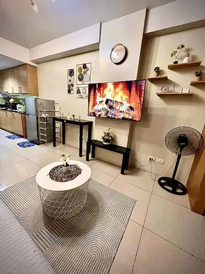 a living room with a table and a fireplace at Staycation Near Mall of Asia in Manila
