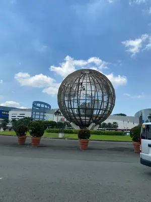 a metal sphere in a parking lot with potted plants at Shore - Spacious Room with Balcony - 52D in Manila