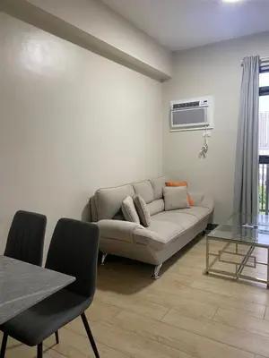 a living room with a couch and a table at Gentry Manor 1BR with Balcony Near Okada - 6A in Manila