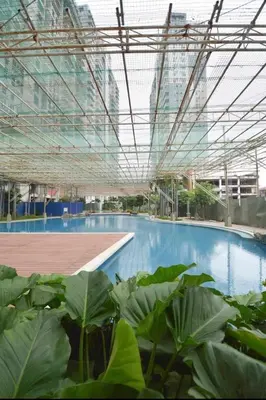 a large swimming pool in a building with plants at Kasara Pasig Staycation in Manila