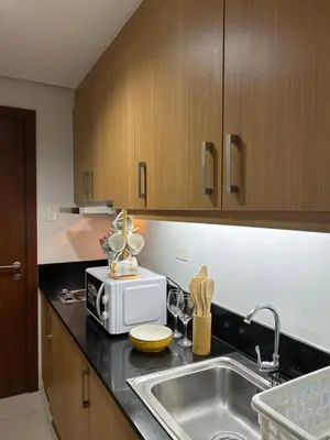 a kitchen with a sink and a microwave at Milk and honey condotel in Manila