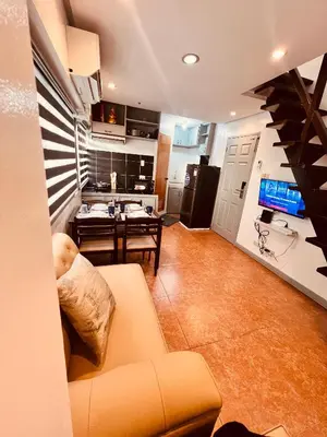 a living room with a couch and a kitchen at G's Bnb in Manila