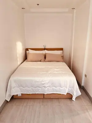 a bed with white sheets and pillows in a room at G's Bnb in Manila