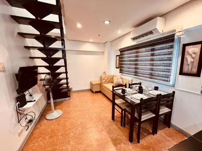 a living room with a dining table and a wine cellar at G's Bnb in Manila