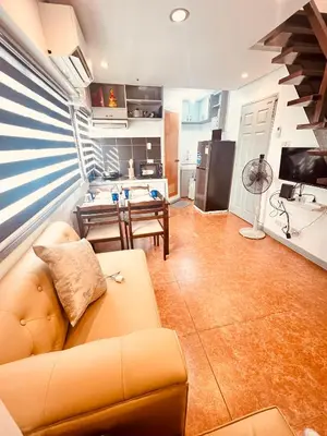 a living room with a couch and a kitchen at G's Bnb in Manila