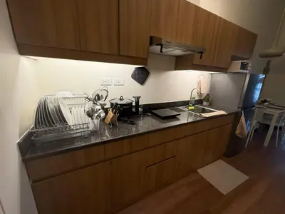 a kitchen with wooden cabinets and a counter top at The Camden Place Family Group Apartment Condo Unit in Manila