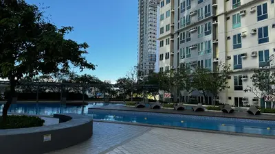 a swimming pool in front of two tall buildings at 2 Bedroom Unit with Queen-sized Beds near NAIA T3 in Manila
