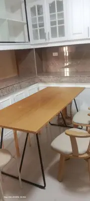 a wooden table and chairs in a kitchen at Victoria's capsule bed in Manila