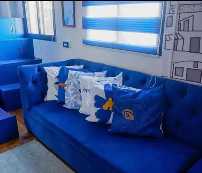 a blue couch with pillows on it in a room at Affordable Bed And Breakfast along Ortigas Ave in Cupang