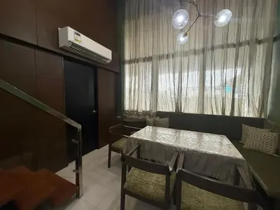 a dining room with a table and chairs and a window at Modern Loft in Newport City - 2BR and 2BA in Manila