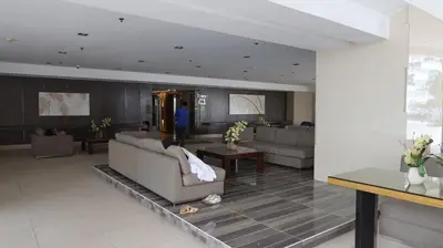a living room with couches and a person in the background at 1BR Amenity View Room at Shore Residences, Pasay Near MOA & Airport in Manila