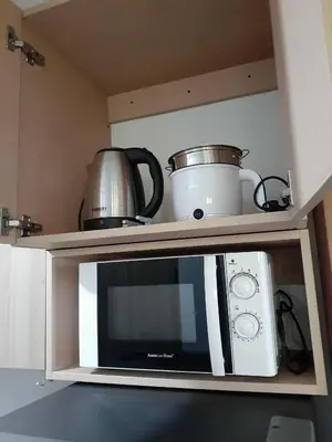 a microwave oven with pots and pans on top of it at GB Travelers Rest at Shore 2 Residences in Manila