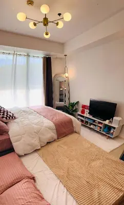 a bedroom with a large bed and a flat screen tv at MG Labels Property in Manila
