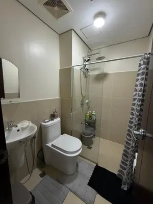 a bathroom with a toilet and a shower and a sink at Paseo Verde at Real in Manila