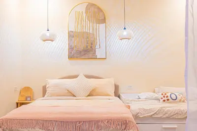 a bedroom with a bed and two pendant lights at Casa Dapyo in Sampong