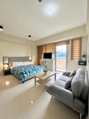 a bedroom with a bed and a couch and a tv at KIEL HOTEL - Manila Airport NAIA Terminal 3 in Manila
