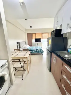 a kitchen and living room with a table and a couch at KIEL HOTEL - Manila Airport NAIA Terminal 3 in Manila