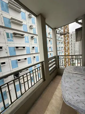 a balcony with a bed and two large windows at 1BR LaVerti Minalist affordable family staycation in Manila