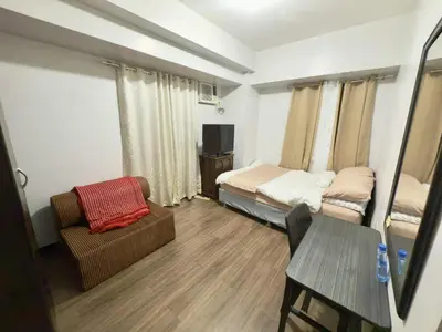 a small room with a bed and a couch and a chair at 1BR LaVerti Minalist affordable family staycation in Manila