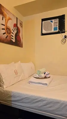 a bed in a room with two towels on it at Jazz Tower A Cozy Room for 2 Adults in Manila