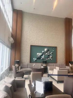 a living room with couches and a tv on a wall at Boho Cove PH in Manila