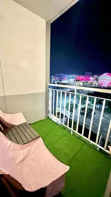 a room with a balcony with a view of the city at MOA Staycation Condotel in Manila