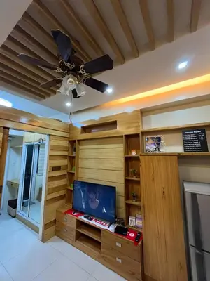 a living room with a tv and a ceiling fan at MOA Staycation Condotel in Manila