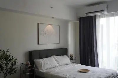 a bedroom with a bed and a large window at Bruné - Parañaque in Manila