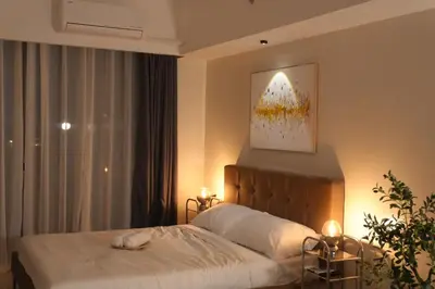a bedroom with a bed with a cat laying on it at Bruné - Parañaque in Manila