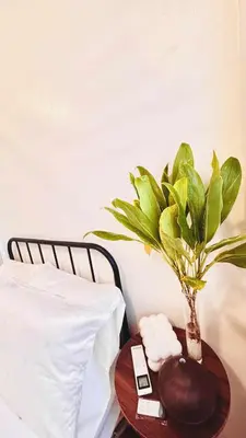 a table with a vase on it next to a bed at Minimalist Condo near NAIA Free Netflix Pool Balcony in Manila