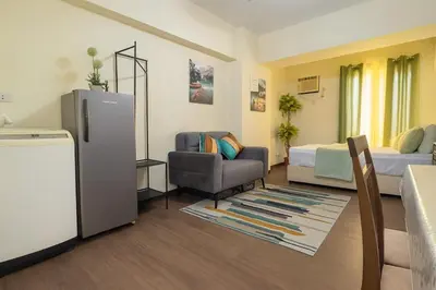 a room with a refrigerator and a bed and a chair at La Verti Residences 1524 in Manila