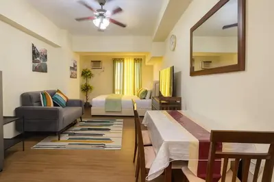 a living room with a bed a couch and a mirror at La Verti Residences 1524 in Manila