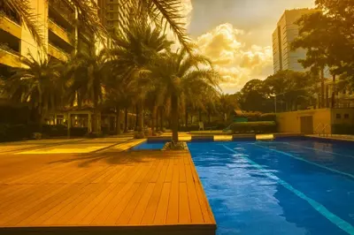 a swimming pool with palm trees next to a building at La Verti Residences 1520 in Manila