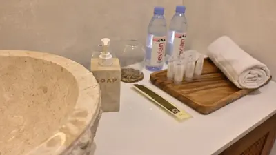 a bathroom counter with a sink and bottles of water at Nusa Villa in Malinta