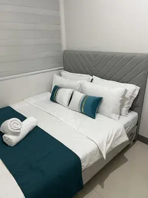 a large white bed with blue and white pillows at Comfort & Productivity Rainy Season WFH Retreat in Manila