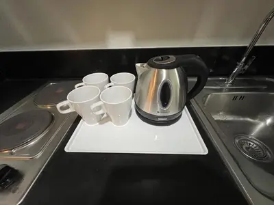 a tea kettle and four coffee cups on a counter at Comfort & Productivity Rainy Season WFH Retreat in Manila