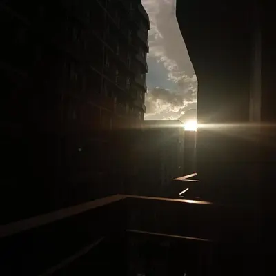 a view of a building with the sun in the sky at Comfort & Productivity Rainy Season WFH Retreat in Manila