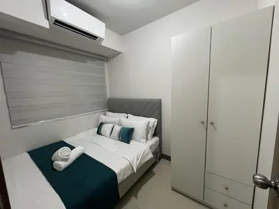 a small bedroom with a bed with towels on it at Comfort & Productivity Rainy Season WFH Retreat in Manila