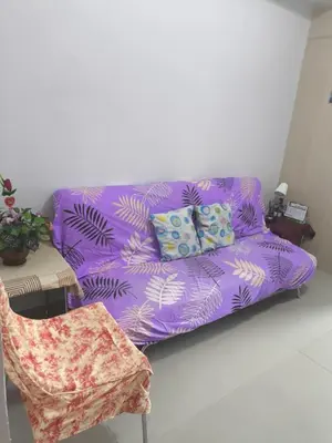 a purple couch in a living room with a chair at Sea Residence-Rosa in Manila
