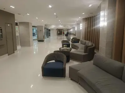a lobby with couches and chairs in a building at Sea Residence-Rosa in Manila