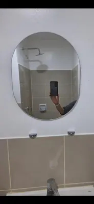a person taking a picture of a mirror in a bathroom at SMDC South Residences in Manila