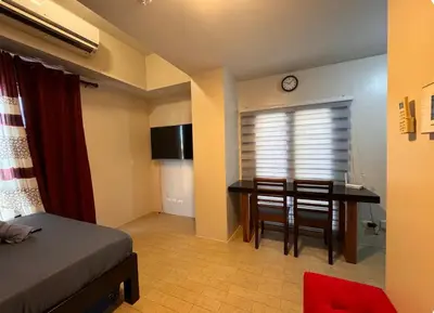 a bedroom with a desk and a table with chairs at Walkable to and from NAIA 3 and Resorts World in Manila