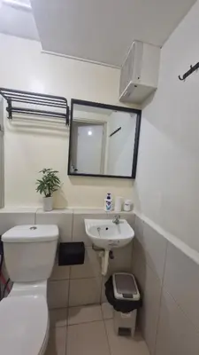 a bathroom with a toilet and a sink and a mirror at Kage-no-Wa Suite Netflix, Disney, HBO 2BR in Manila