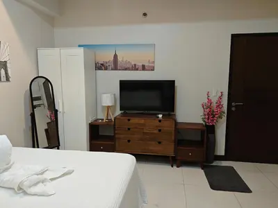 a bedroom with a tv on a wooden dresser at RL airport haven in Manila